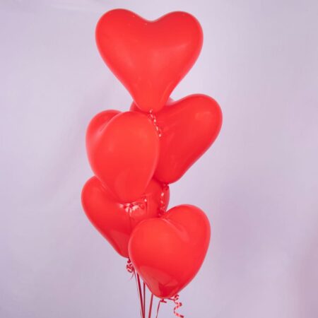 A bunch of red heart-shaped balloons on a white background