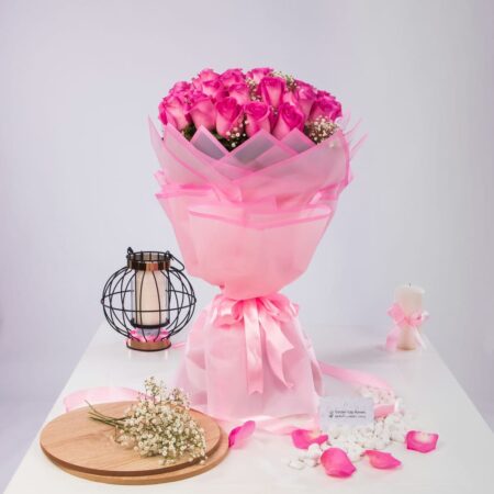 A bouquet of pink roses with white baby's breath