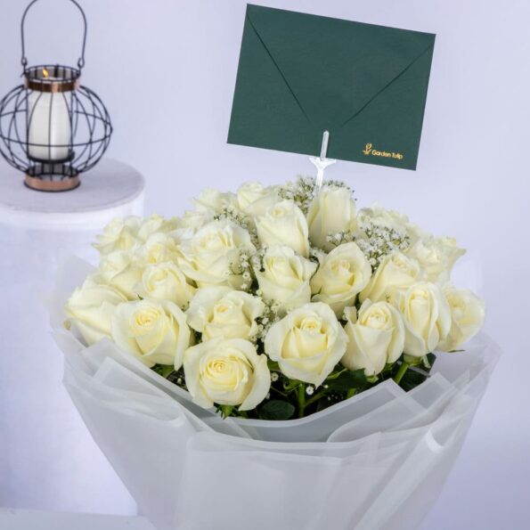 close up of white rose bouquet with baby breath & envelope
