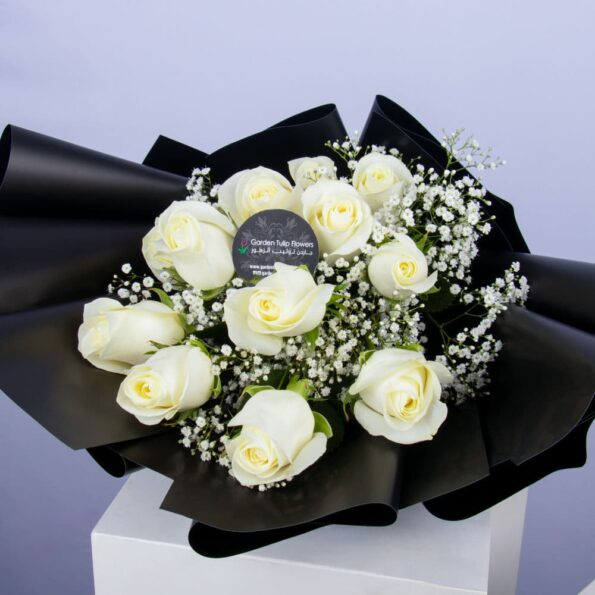 Bouquet of white roses in a black wrapping with a white bow