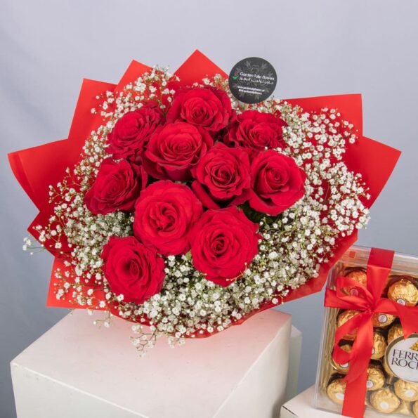 A bouquet of red roses and baby's breath with a box of Ferrero Rocher chocolates