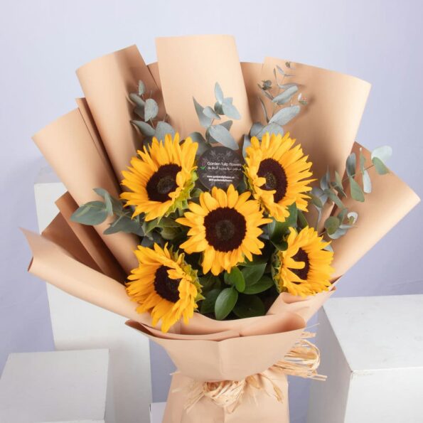 A bouquet of sunflowers wrapped in brown paper