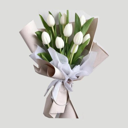 A bouquet of white tulips in a nice wrapping and tied with white ribbon
