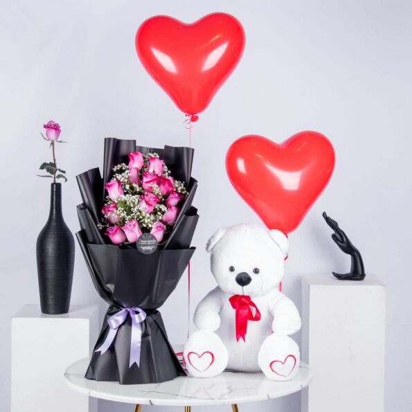 Bouquet of pink roses, teddy bear, and heart-shaped balloons