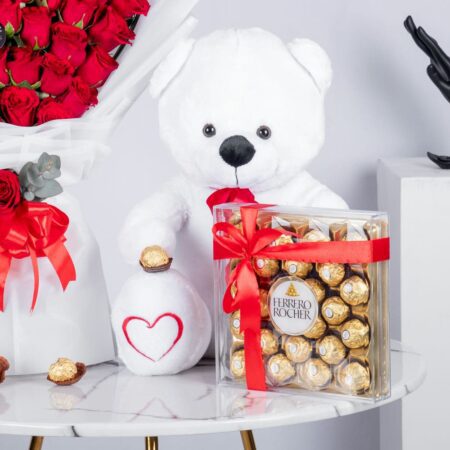 A close up view of red rose bouquet with chocolate and teddy bear