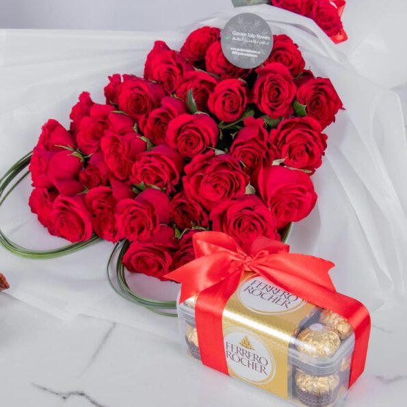 A close up view of red rose bouquet in heart shape with chocolates