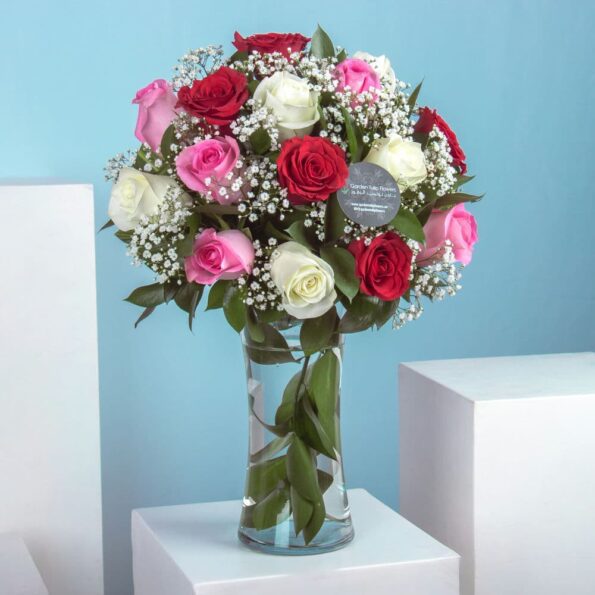 A bouquet of pink, red and white roses in a vase