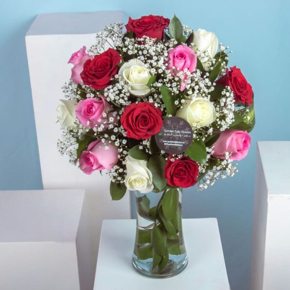 A bouquet of pink, red and white roses in a vase