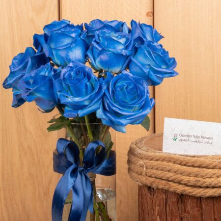 Blue roses in a vase tied with blue ribbon