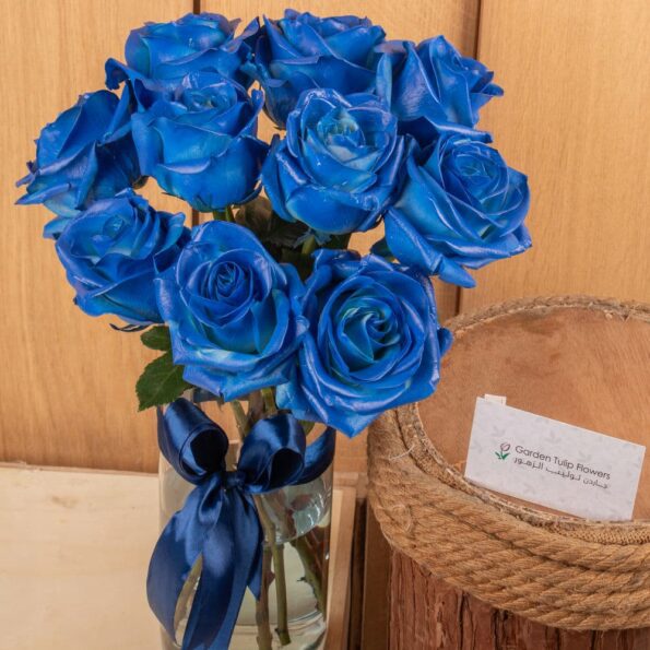 Blue roses in a vase tied with blue ribbon