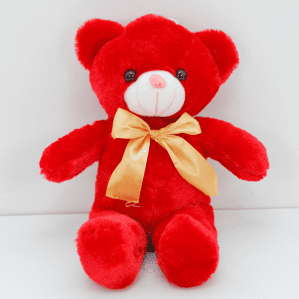 small red teddy bear tied with gold color ribbon