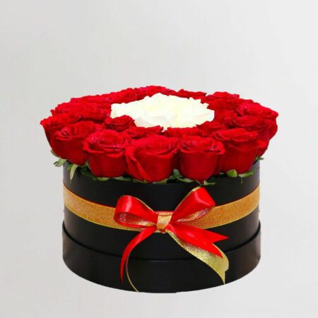 Red and white roses arranged in a black box and tied with red ribbon