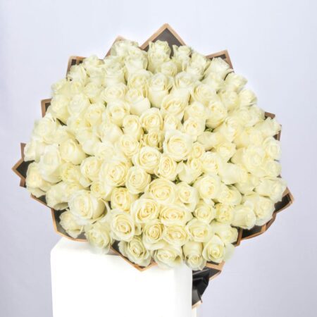 Top view of bouquet of 101 white roses, wrapped in eco-friendly satin paper and tied with a ribbon