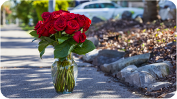 red roses in a glass vase placed on the empty road